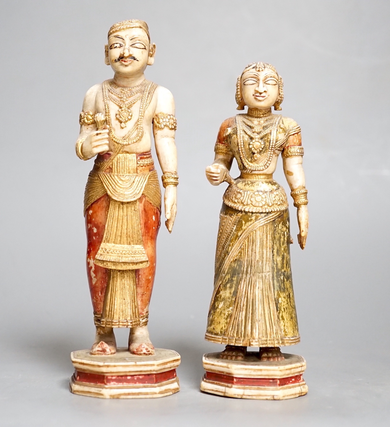 A pair of 18th century painted carved Indian ivory figures, male 7.6cm high female: 5.5cm high